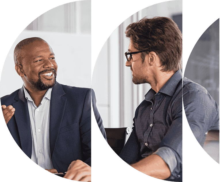 Deux hommes dans un cadre professionnel engageant une conversation, l'un souriant et l'autre écoutant attentivement.