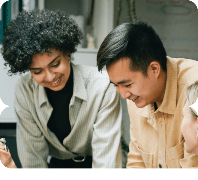 Trois jeunes professionnels collaborant sur des documents autour d'une table.